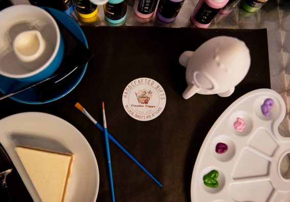 Painting whilst enjoying tea and cake. A painting activity set up for a customer with a cup of tea and a slice of cake to the side.