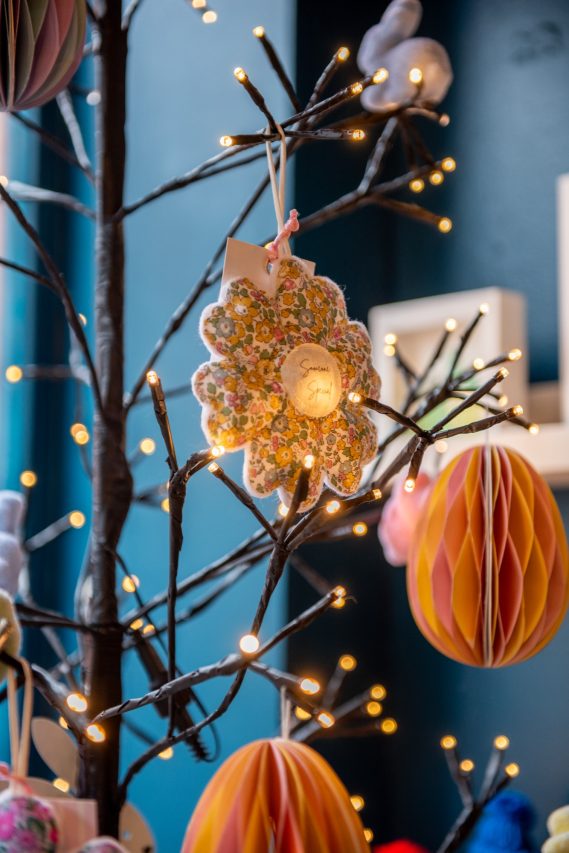 Display decoration. Decorative paper display and handmade gift hanging on a lit up tree.